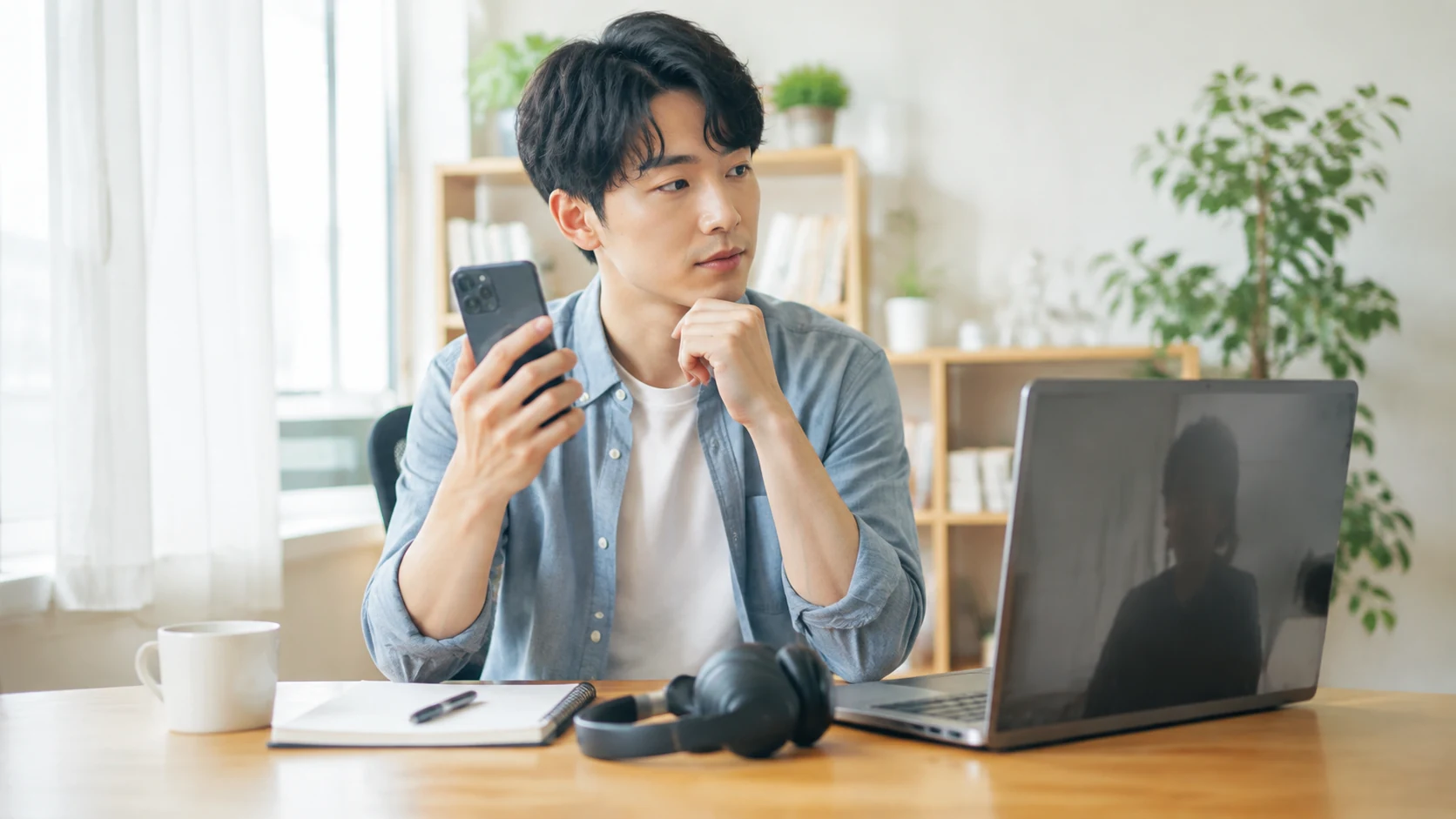 スマートフォンとノートパソコンを前にAI英会話とオンライン英会話を比較する学習者